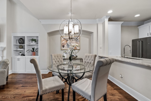 dining space featuring sink, an inviting chandelier, dark hardwood / wood-style floors, and ornamental molding