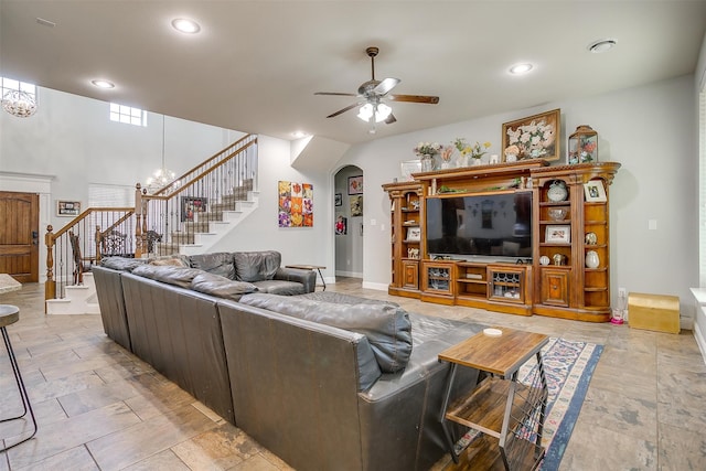 living room with ceiling fan with notable chandelier