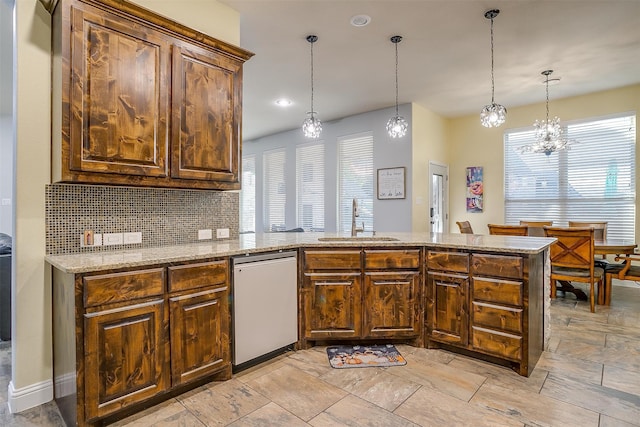 kitchen featuring sink, tasteful backsplash, a notable chandelier, pendant lighting, and dishwashing machine