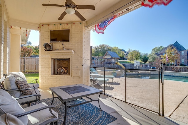 view of patio / terrace with an outdoor living space with a fireplace, ceiling fan, and a fenced in pool