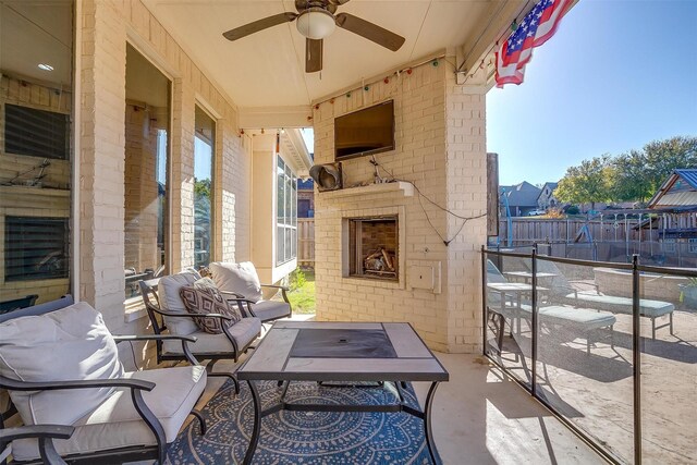 balcony with an outdoor living space with a fireplace, ceiling fan, and a patio area