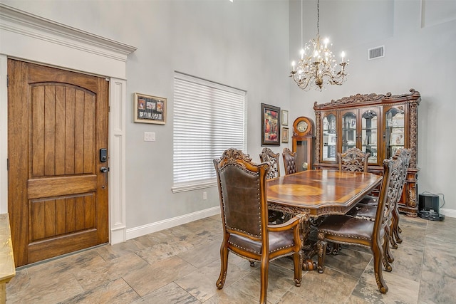 dining space featuring a high ceiling and an inviting chandelier