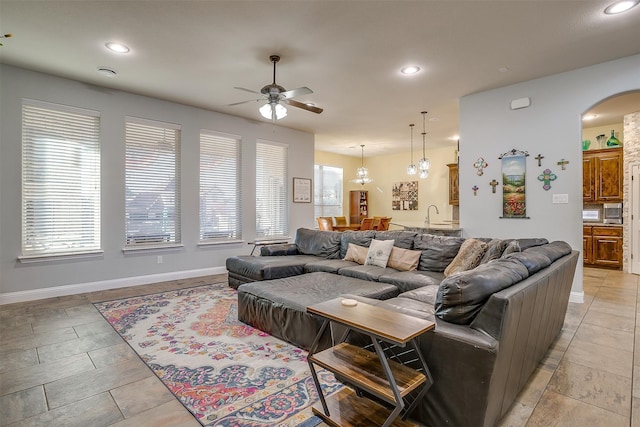 living room with plenty of natural light, ceiling fan, and sink