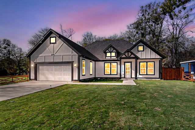 tudor-style house featuring a lawn and a garage