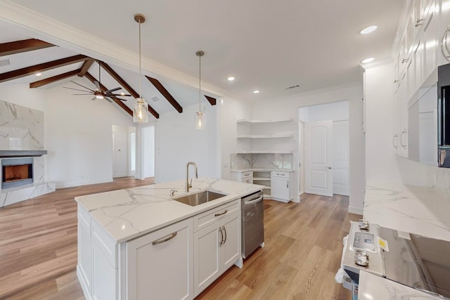 kitchen featuring white cabinetry, sink, lofted ceiling with beams, pendant lighting, and a center island with sink