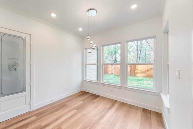 unfurnished dining area with light hardwood / wood-style flooring and crown molding