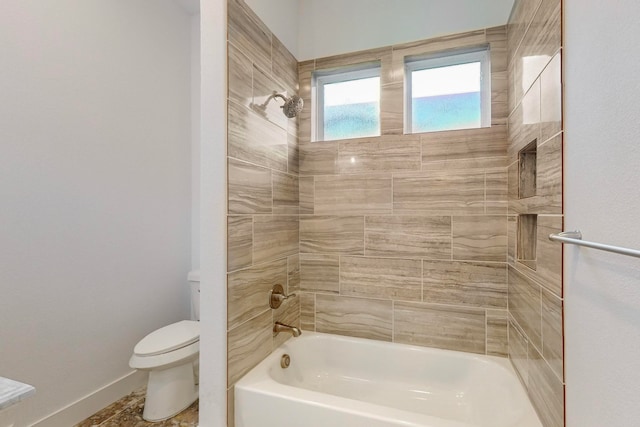 bathroom featuring toilet and tiled shower / bath