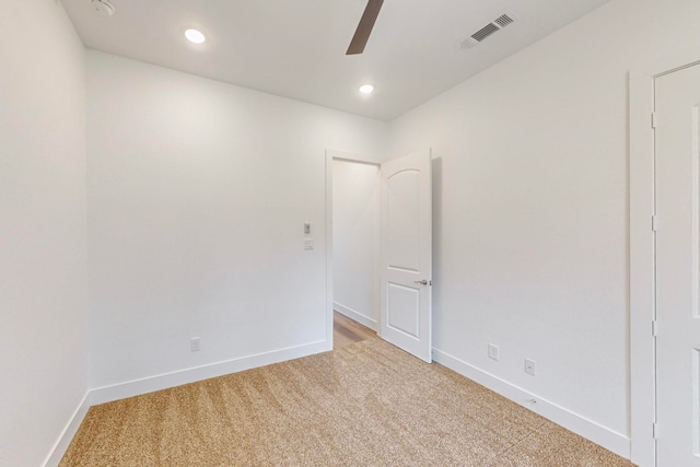 spare room featuring light colored carpet and ceiling fan