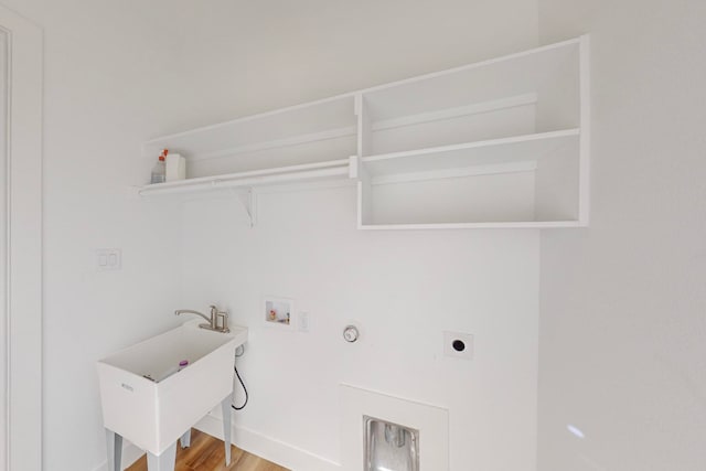 washroom with hardwood / wood-style floors, sink, hookup for a gas dryer, hookup for a washing machine, and electric dryer hookup