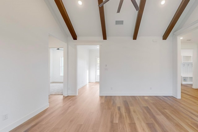 empty room with lofted ceiling with beams, light hardwood / wood-style floors, and ceiling fan