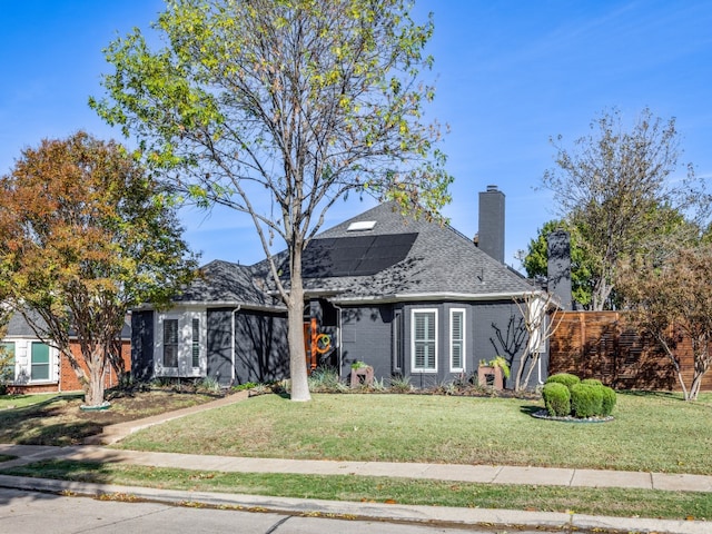 view of front of home with solar panels and a front lawn