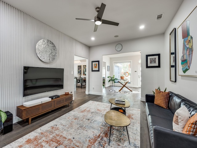 living room featuring ceiling fan and dark hardwood / wood-style floors