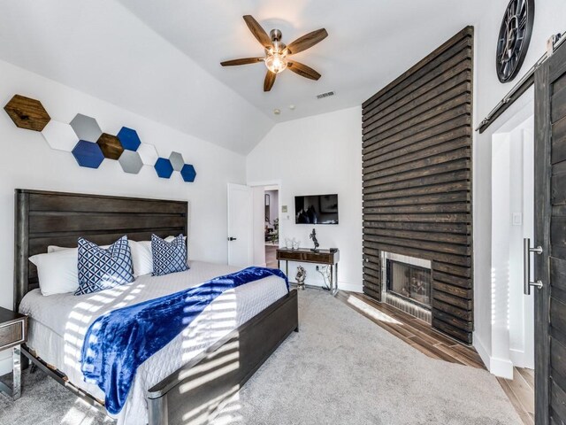 bedroom with a fireplace, ceiling fan, hardwood / wood-style floors, and lofted ceiling