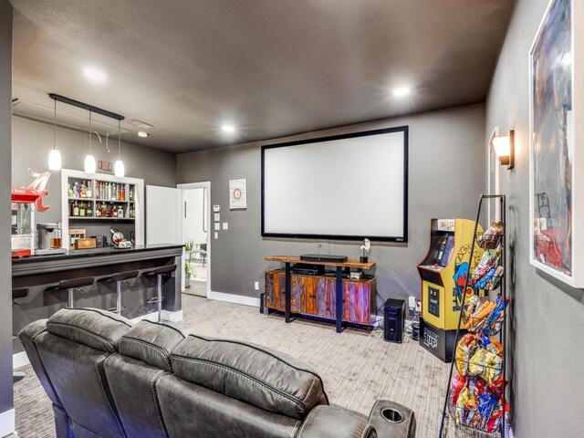 carpeted cinema room featuring bar