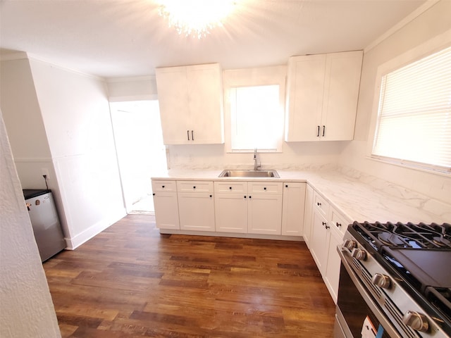 kitchen with dark hardwood / wood-style floors, white cabinetry, sink, crown molding, and stainless steel range with gas stovetop