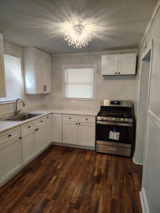 kitchen with white cabinets, sink, stainless steel gas range, and dark hardwood / wood-style floors