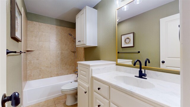 full bathroom with tile patterned floors, tiled shower / bath combo, vanity, and toilet