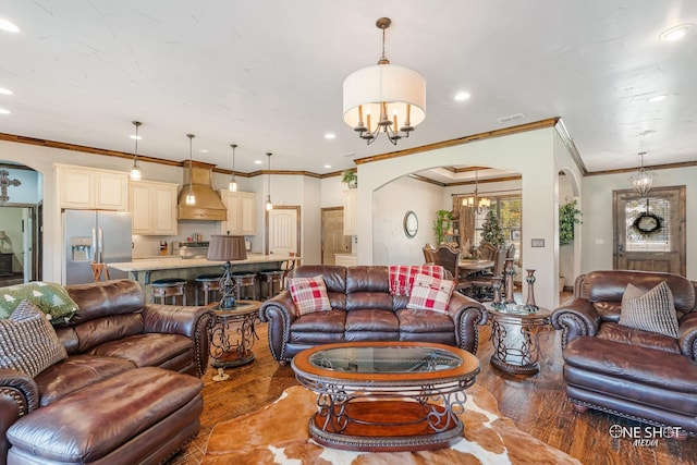 living room with hardwood / wood-style flooring, an inviting chandelier, and ornamental molding