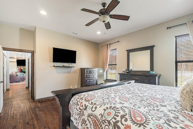 bedroom with multiple windows, dark hardwood / wood-style flooring, and ceiling fan