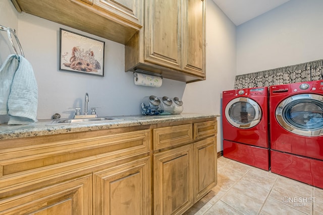 clothes washing area featuring cabinets, light tile patterned floors, sink, and washing machine and clothes dryer