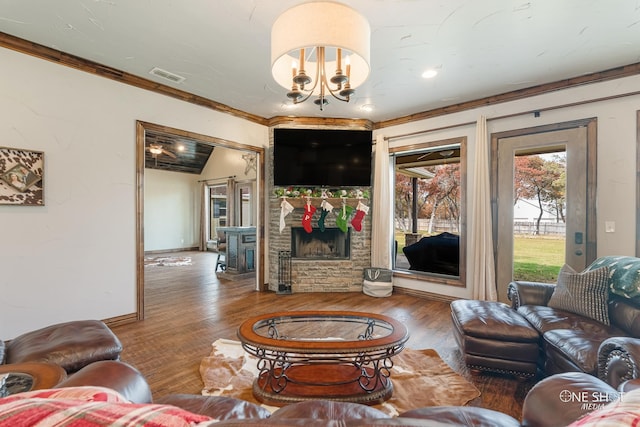 living room with a notable chandelier, wood-type flooring, a fireplace, and ornamental molding