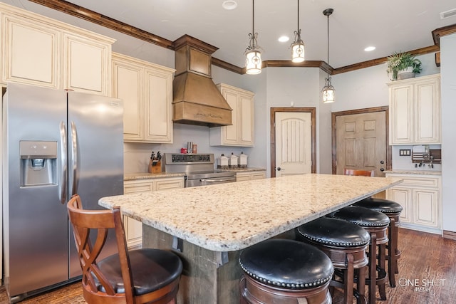 kitchen featuring cream cabinetry, dark hardwood / wood-style floors, pendant lighting, and appliances with stainless steel finishes