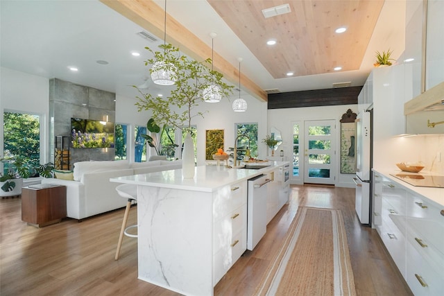 kitchen featuring white cabinets, a large island, and sink