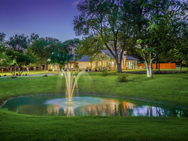 view of community with a water view and a lawn