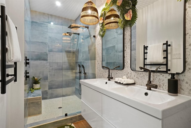 full bath featuring a sink, a shower stall, and double vanity