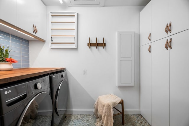 clothes washing area with separate washer and dryer, cabinet space, and baseboards