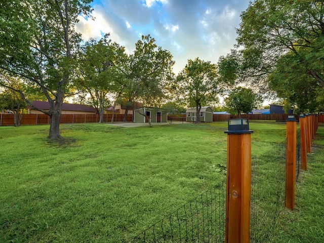 view of yard with a fenced backyard and an outbuilding