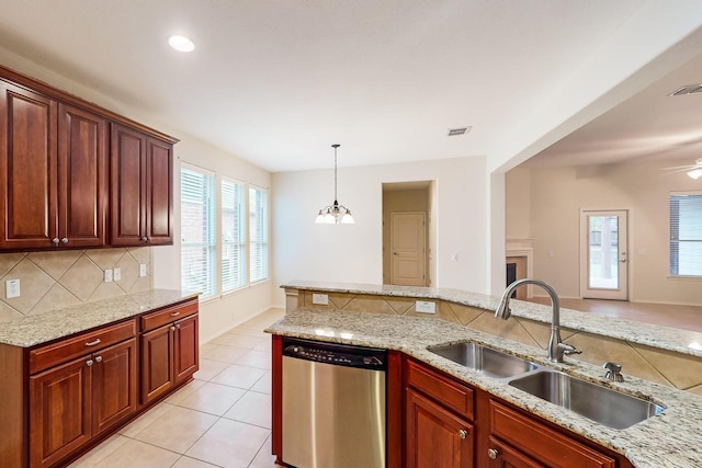 kitchen featuring sink, light stone counters, dishwasher, pendant lighting, and decorative backsplash