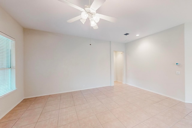 tiled spare room featuring ceiling fan