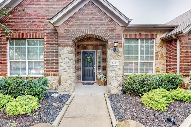 doorway to property featuring brick siding and stone siding