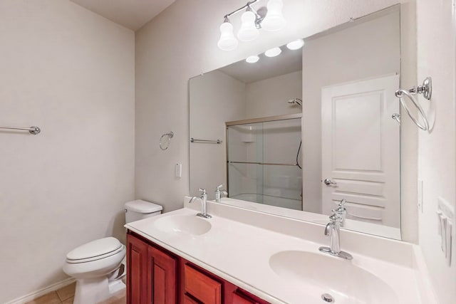 bathroom with toilet, vanity, tile patterned floors, and a shower with shower door