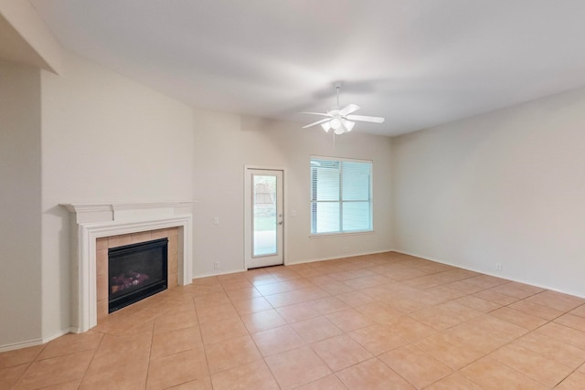 unfurnished living room featuring ceiling fan, a tile fireplace, and light tile patterned floors