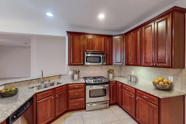 kitchen featuring sink, light tile patterned floors, appliances with stainless steel finishes, backsplash, and light stone counters