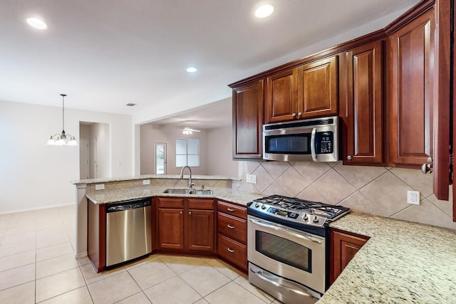 kitchen with sink, light tile patterned floors, kitchen peninsula, stainless steel appliances, and decorative backsplash