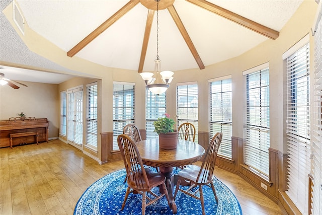 dining room featuring light wood-type flooring, visible vents, and lofted ceiling with beams