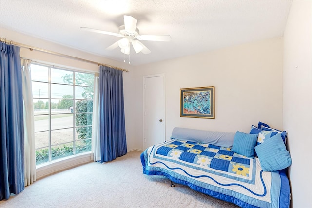 bedroom featuring ceiling fan, carpet, and a textured ceiling