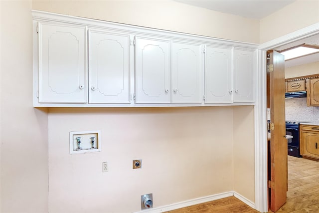 washroom with washer hookup, cabinets, light hardwood / wood-style floors, and hookup for an electric dryer