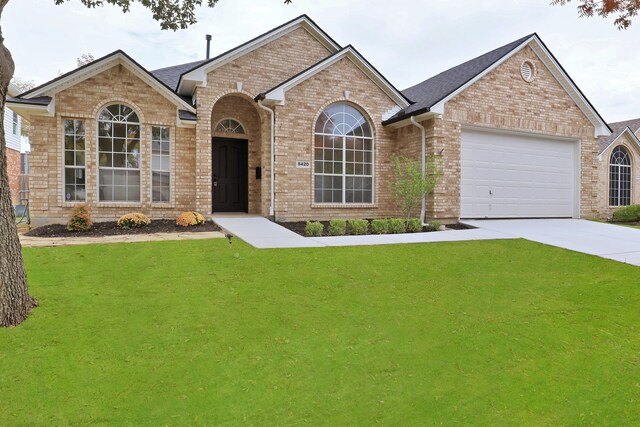 single story home featuring a garage and a front lawn