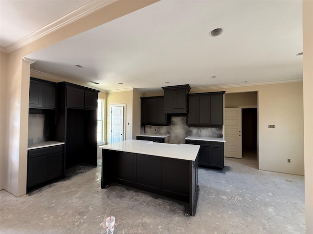 kitchen with backsplash, crown molding, and a center island