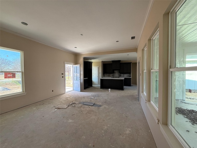 unfurnished living room with ornamental molding and a healthy amount of sunlight