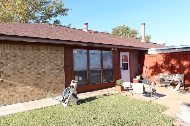 back of house with a lawn and a patio area