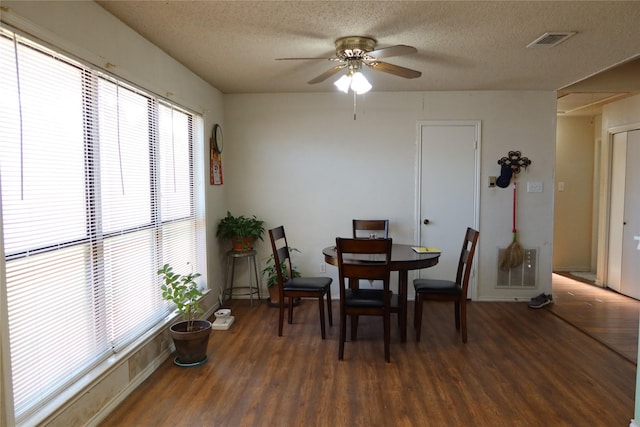 dining space with dark hardwood / wood-style floors, ceiling fan, and a textured ceiling