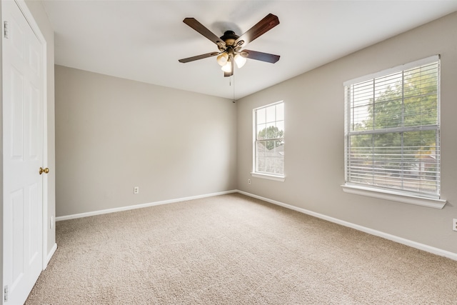 carpeted spare room with ceiling fan