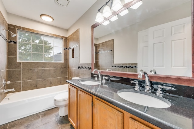 full bathroom with tile patterned flooring, toilet, vanity, tile walls, and tiled shower / bath