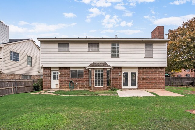 back of property featuring french doors, a patio area, and a lawn