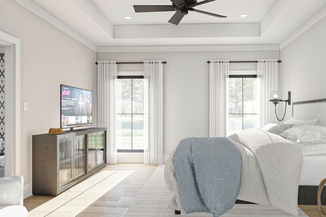 bedroom featuring a tray ceiling, multiple windows, and light hardwood / wood-style floors